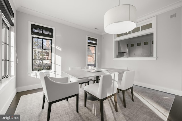 dining room with crown molding and dark wood-type flooring