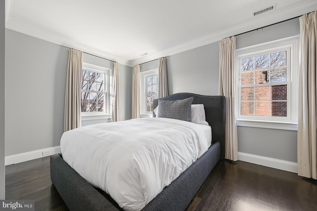 bedroom with ornamental molding and dark hardwood / wood-style flooring