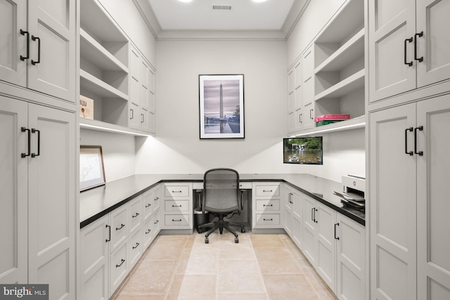 home office featuring crown molding and built in desk