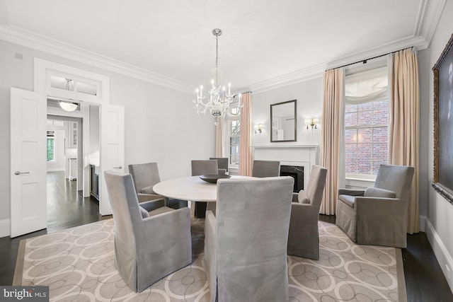 dining room featuring light wood-type flooring, crown molding, and a notable chandelier