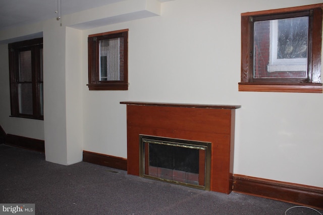 unfurnished living room featuring dark carpet