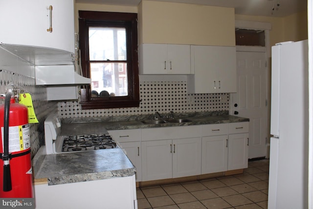 kitchen with sink, range, white cabinetry, backsplash, and white fridge