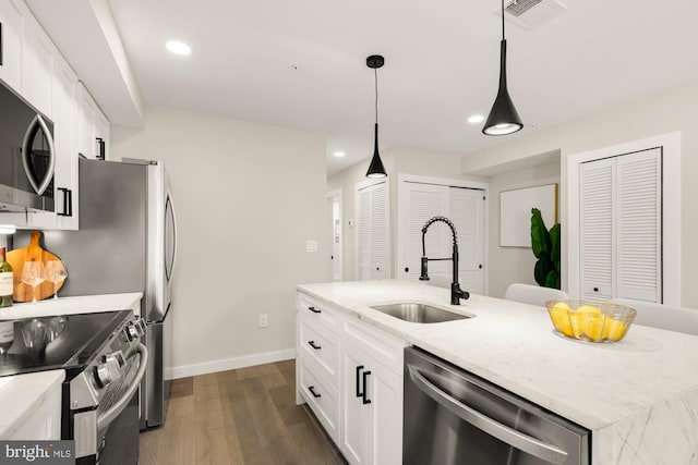 kitchen with sink, stainless steel appliances, white cabinetry, and decorative light fixtures