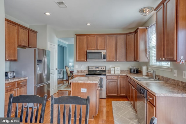 kitchen featuring light wood-style flooring, a sink, visible vents, light countertops, and appliances with stainless steel finishes