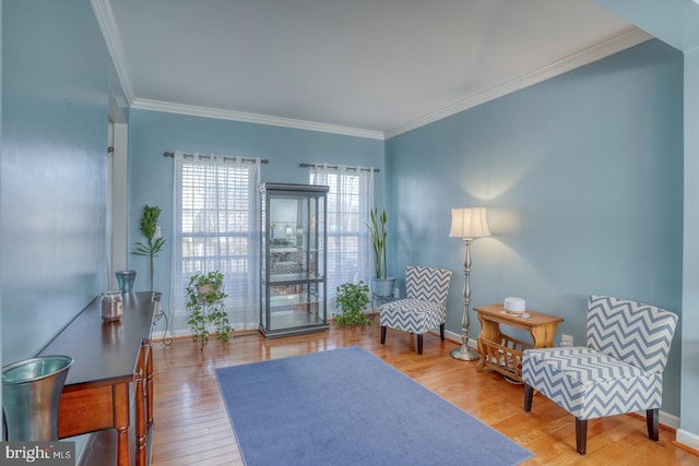 sitting room with crown molding, baseboards, and wood finished floors