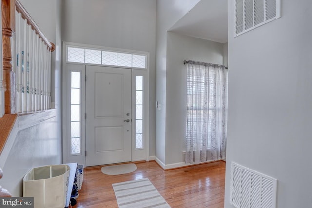 foyer featuring a healthy amount of sunlight, hardwood / wood-style flooring, and visible vents