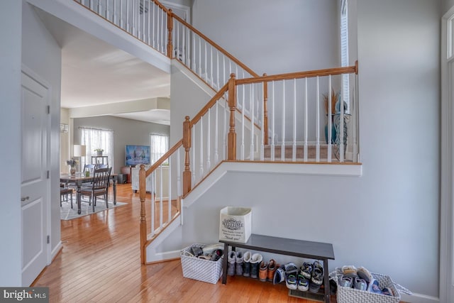 stairway featuring a high ceiling and wood-type flooring