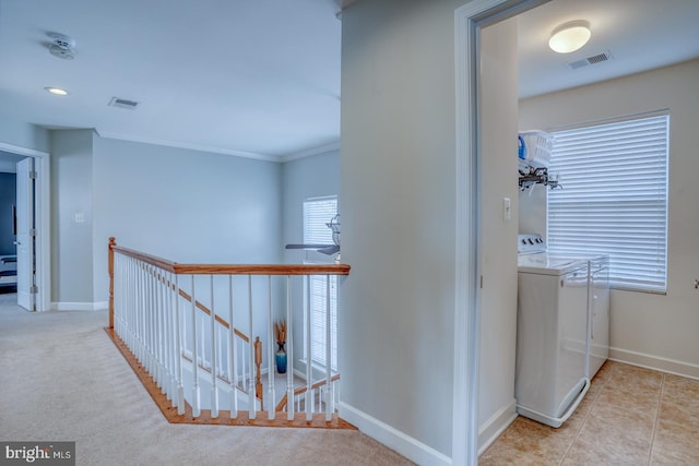 corridor with visible vents, washing machine and dryer, an upstairs landing, and baseboards