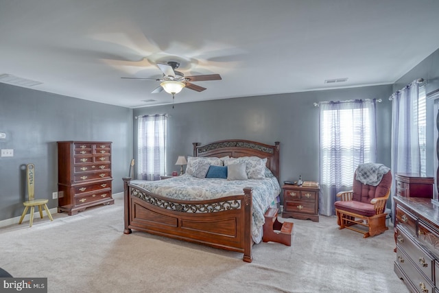 bedroom with ceiling fan, multiple windows, and visible vents