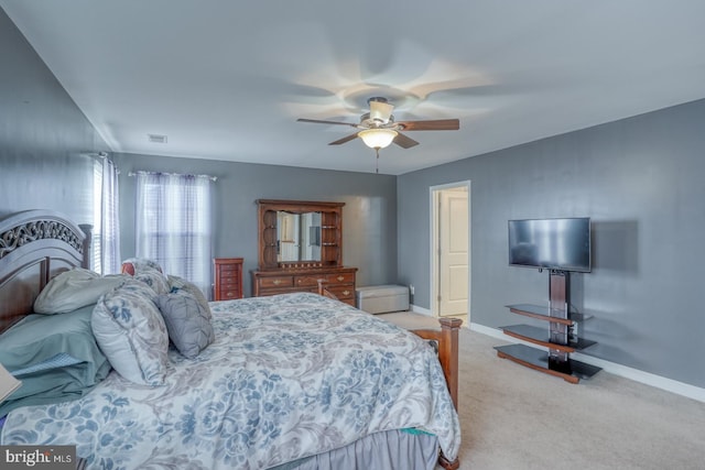 bedroom with a ceiling fan, light colored carpet, visible vents, and baseboards