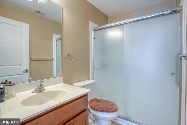 full bathroom featuring toilet, a shower stall, visible vents, and vanity