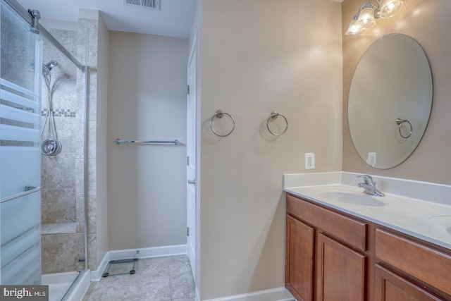 bathroom featuring a sink, visible vents, baseboards, a tile shower, and double vanity