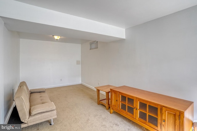 living area featuring light carpet and baseboards