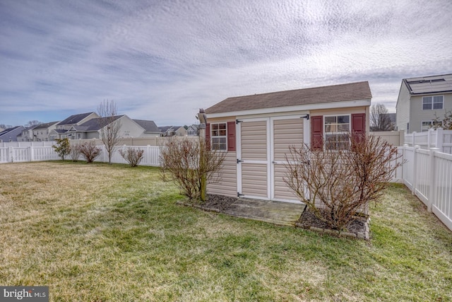 view of yard featuring an outbuilding, a fenced backyard, a residential view, and a shed