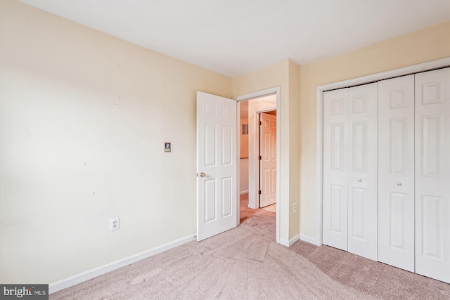 unfurnished bedroom featuring carpet, baseboards, and a closet