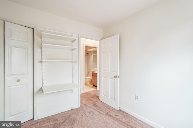 unfurnished bedroom featuring light carpet and baseboards