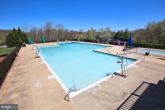 community pool featuring fence and a patio