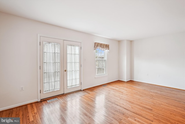 interior space featuring french doors, visible vents, baseboards, and hardwood / wood-style floors