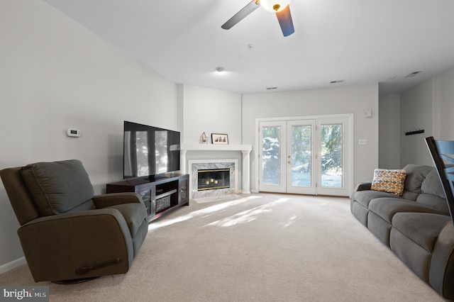 living room with ceiling fan, a fireplace, and carpet flooring