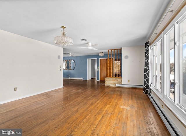 unfurnished living room featuring hardwood / wood-style flooring, a baseboard radiator, and ceiling fan with notable chandelier