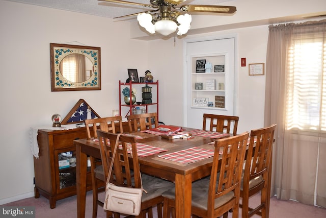 carpeted dining room with ceiling fan and plenty of natural light