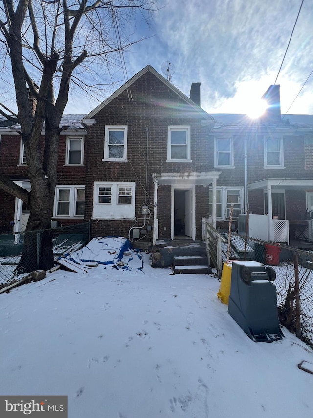 view of snow covered rear of property