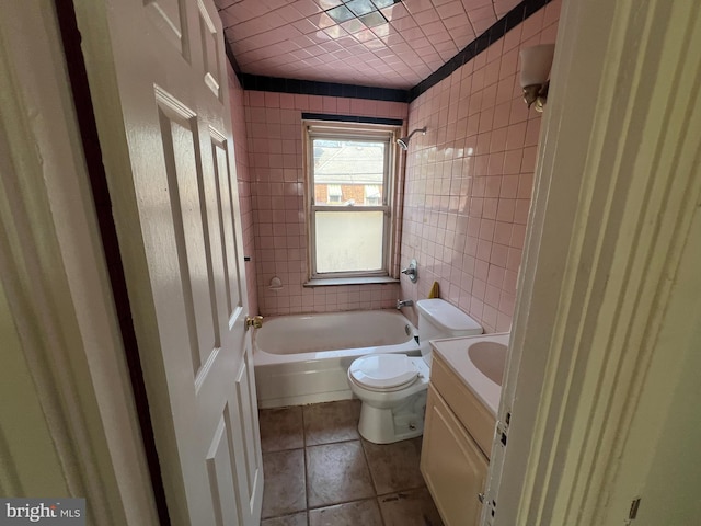 full bathroom featuring vanity, toilet, tile walls, and shower / bathing tub combination