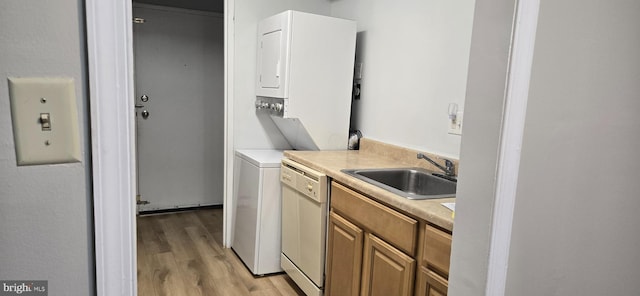 laundry room featuring sink, stacked washer and dryer, and light wood-type flooring