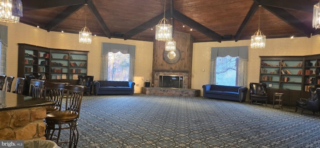 carpeted living room featuring a fireplace, beam ceiling, and wooden ceiling