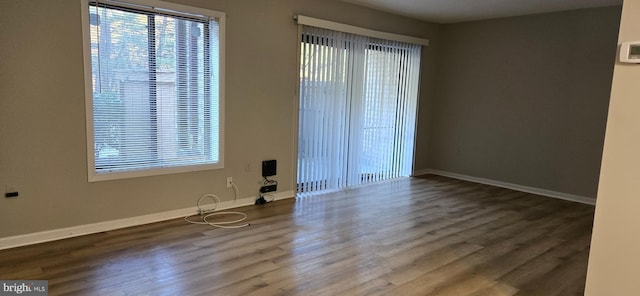 empty room with dark hardwood / wood-style flooring