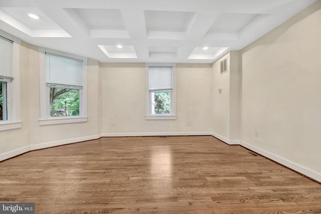 spare room with plenty of natural light, coffered ceiling, beam ceiling, and light wood-type flooring