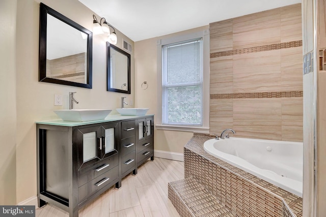 bathroom featuring vanity, tiled tub, and tile patterned flooring