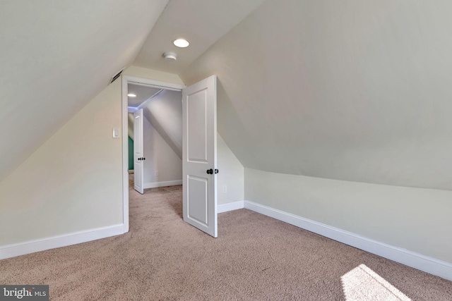 bonus room with light colored carpet and lofted ceiling