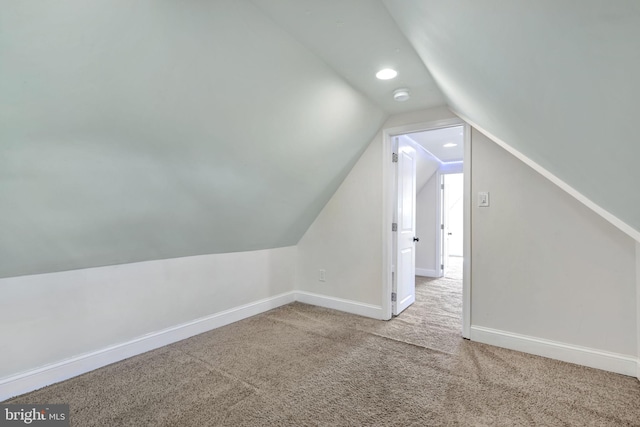 bonus room with carpet flooring and vaulted ceiling