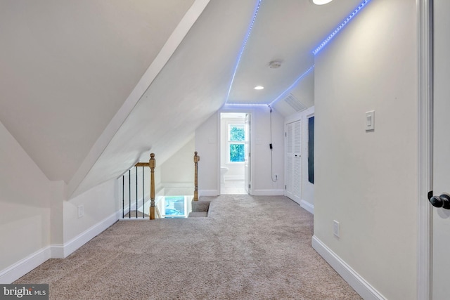 additional living space featuring vaulted ceiling and carpet floors