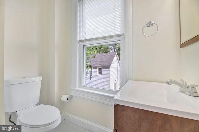 bathroom with toilet, tile patterned floors, and vanity