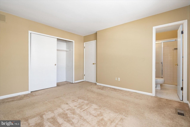 unfurnished bedroom with a closet, carpet flooring, and connected bathroom