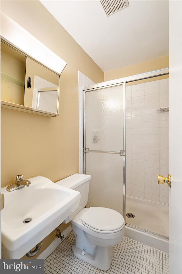 bathroom with sink, toilet, tile patterned flooring, and an enclosed shower