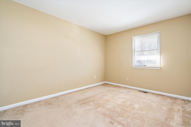 spare room featuring light colored carpet