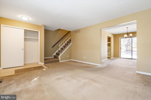 unfurnished living room with a chandelier and carpet flooring