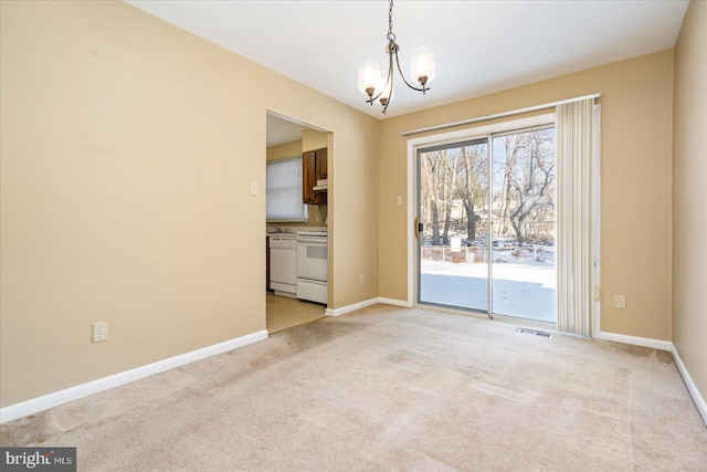 unfurnished room featuring a notable chandelier and light carpet