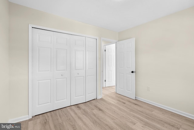 unfurnished bedroom featuring a closet and light hardwood / wood-style flooring