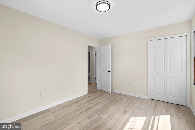 unfurnished bedroom featuring light wood-type flooring and a closet