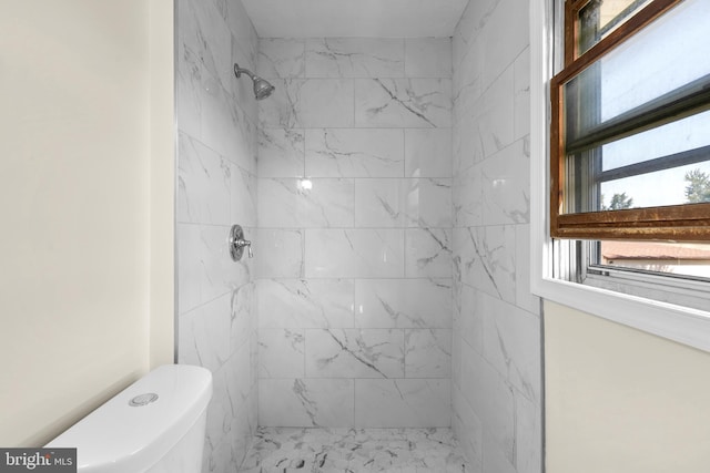 bathroom with tiled shower and toilet