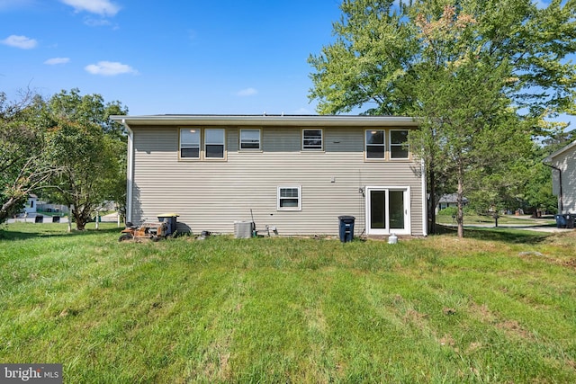 back of property with a yard and central air condition unit