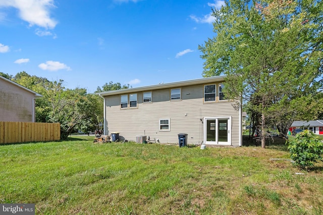 back of property with a yard and central air condition unit