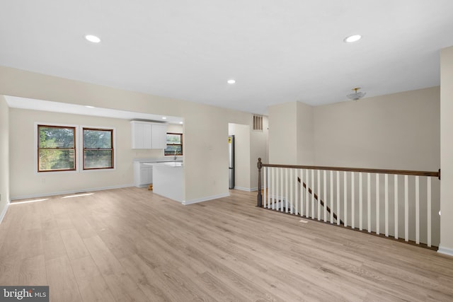 unfurnished room featuring sink and light wood-type flooring