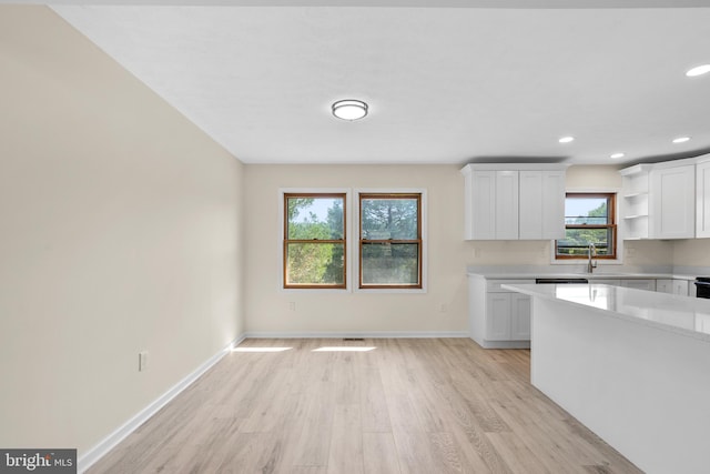 kitchen with sink, white cabinets, and light hardwood / wood-style floors