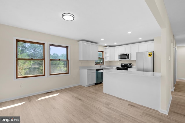 kitchen with white cabinetry, appliances with stainless steel finishes, sink, and light hardwood / wood-style floors