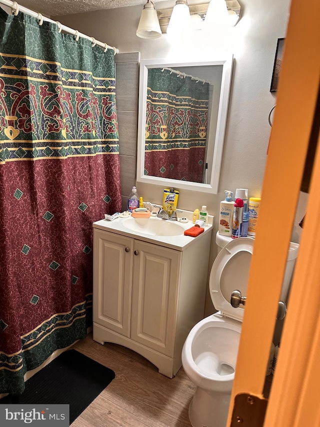 bathroom featuring vanity, hardwood / wood-style floors, and toilet